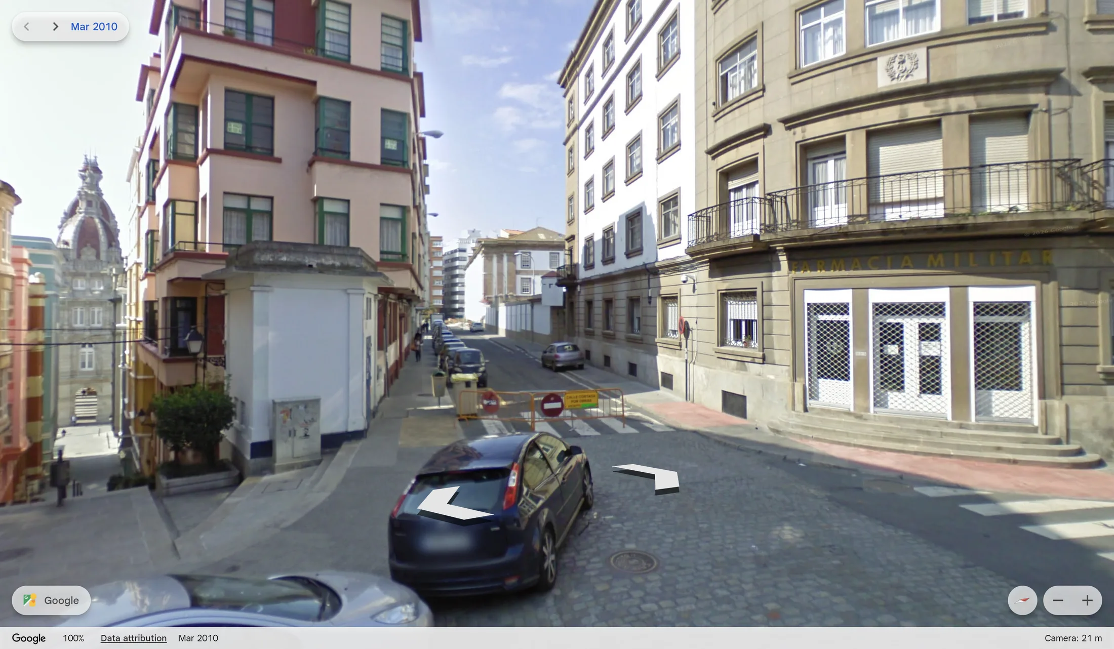 O mesmo recuncho en 2010, unha rúa aberta con coches aparcados e unha barreira.